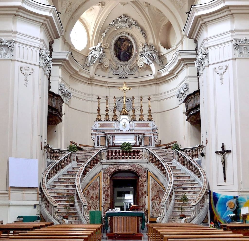 Una scenografica scalinata a doppia rampa conduce all'altare maggiore.